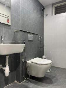 een badkamer met een wit toilet en een wastafel bij Vijey Hotels in Tiruchchirāppalli