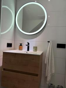 une salle de bain avec un lavabo et un miroir au mur dans l'établissement Haus Dienten Apartments am Hochkoenig, à Dienten am Hochkönig