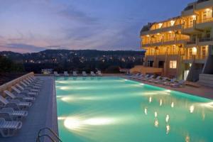 a large swimming pool with chairs and a building at Panorama Hotel in Sandanski