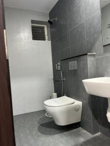 een badkamer met een wit toilet en een wastafel bij Vijey Hotels in Tiruchchirāppalli +32 foto's