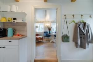 una cucina con un corridoio con una stanza con un tavolo di Bullerbü im Uthland a Braderup
