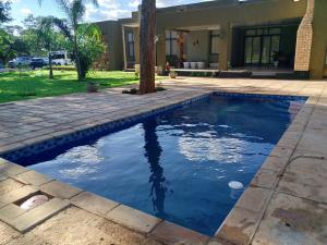 a pool with blue water in front of a house at Zengu in Lusaka