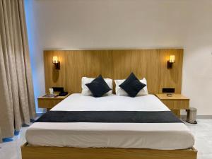 a bedroom with a large bed and two desks at The Hyde Park Inn in Bilāspur