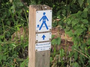 ein blau-weißes Schild auf einem Holzpfahl in der Unterkunft Padborg Inn - Simple Rooms & Modern Apartments in Padborg + 1 Foto