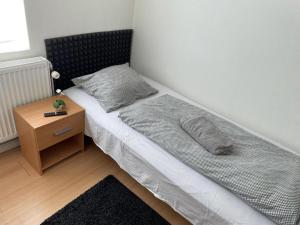 a small bedroom with a bed with a night stand at Padborg Inn - Simple Rooms & Modern Apartments in Padborg +14 photos