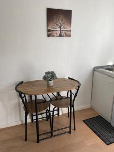 ein Tisch und ein Stuhl in einer Küche mit einem Baum in der Unterkunft Padborg Inn - Simple Rooms & Modern Apartments in Padborg