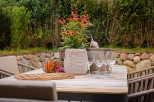 a table with wine glasses and a vase of flowers at Haus Möhre in Tinnum