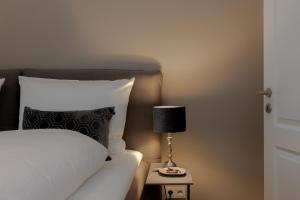 a bed with a black and white pillow and a lamp at Haus Möhre in Tinnum