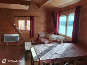 een kamer met een bed, een bank en ramen bij Chalets Sybelles in Saint-Sorlin-dʼArves