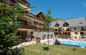 - une vue sur un hôtel avec une piscine dans l'établissement Résidence Odalys Les Sybelles, à Saint-Sorlin-dʼArves