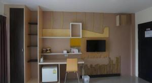 ein Zimmer mit einem Schreibtisch und einem Fernseher an der Wand in der Unterkunft The Rice Hotel in Roi Et + 174 Fotos