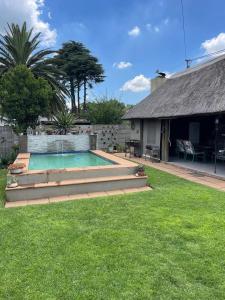 a backyard with a swimming pool and a house at Shady Seringa Accommodation in Vanderbijlpark
