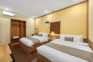 een hotelkamer met twee bedden in een kamer bij Lucas Boutique Home Hue in Thôn Trường Giang