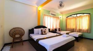 une chambre d'hôtel avec deux lits et une chaise dans l'établissement Happy Zone Hostel, à Siem Reap