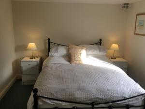 a bedroom with a large bed with two night stands at Leadenham Cottage in Oakham