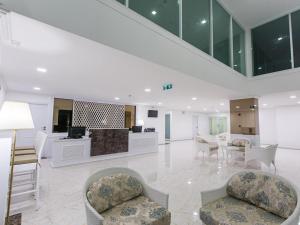 eine große Lobby mit Stühlen und eine Rezeption in der Unterkunft B2 Hua Hin Premier Hotel in Hua Hin