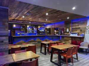 een restaurant met houten tafels en stoelen en een bar bij Hôtel du Centre - Restaurant Lelex'ir in Lélex