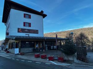 een gebouw met rode containers ervoor bij Hôtel du Centre - Restaurant Lelex'ir in Lélex +6 foto's