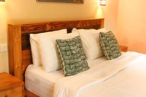 een slaapkamer met een bed met witte lakens en kussens bij Ananda House in Ubud +30 foto's