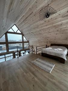 a bedroom with a bed and a large window at Tysha House in Ternopil +34 photos