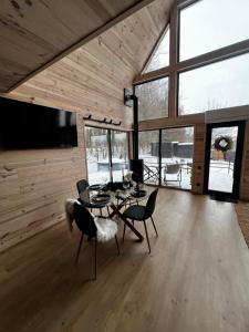 a living room with a table and chairs and a tv at Tysha House in Ternopil