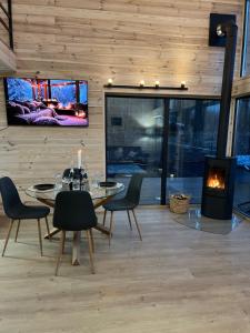 a dining room with a table and chairs and a fireplace at Tysha House in Ternopil
