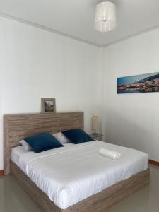 a bedroom with a large white bed with blue pillows at Baan Klang Khao Mountain Viewบ้านกลางเขา เมาเทนวิว in Ban Pang Asok