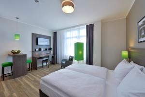 a hotel room with a bed and a tv at Appartello Smarttime living Hamburg in Hamburg