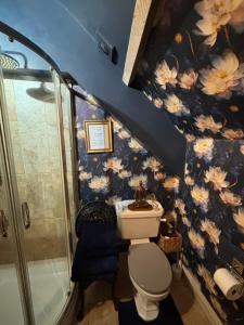een badkamer met een douche en een toilet met bloemen aan de muur bij Dove Cottage in Bisley +68 foto's