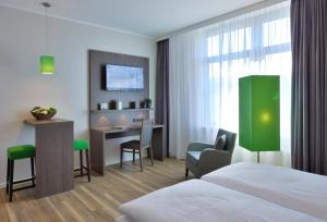 a hotel room with a bed and a desk at Appartello Smarttime living Hamburg in Hamburg