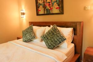 een slaapkamer met een bed met twee kussens erop bij Ananda House in Ubud