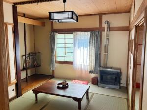a living room with a table and a tv at Hi Song Villa in Otaru