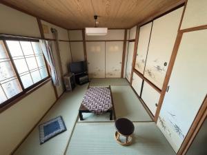 an empty room with a bench and a tv at Hi Song Villa in Otaru +33 photos