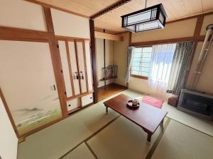 a living room with a table and a tv at Hi Song Villa in Otaru