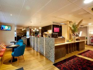 een restaurant met een bar met blauwe stoelen bij ibis Le Mans Est Pontlieue in Le Mans