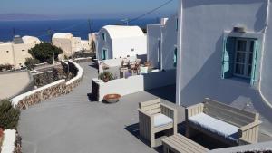 a view of a building with a bench and the ocean at Alonistra Oia Houses in Oia