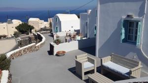 una vista di un edificio con una panchina e l'oceano di Alonistra Oia Houses a Oia