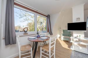 a living room with a table and chairs and a large window at Seehof Boutique Appartements in Büsum