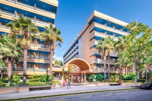 ein Gebäude mit Palmen vor einer Straße in der Unterkunft 4R Playa Park in Salou