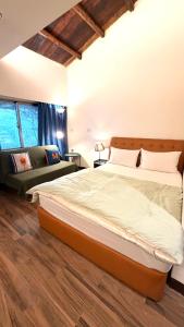une chambre avec un grand lit et un canapé dans l'établissement Jiufen Breeze 九份惠風民宿ｌ6人包棟小屋, à Jiufen