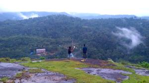 two people standing on the top of a mountain at Skyfall Villa in Chillithodu +1 photo