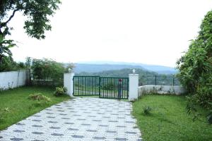 a gate in a yard with a grass field at Skyfall Villa in Chillithodu