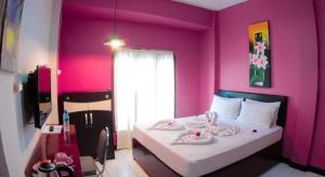 een slaapkamer met een roze kamer met een bed bij FX 72 Ruteng Hotel in Ruteng +69 foto's