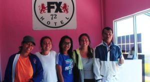 een groep mensen die voor een roze muur staan bij FX 72 Ruteng Hotel in Ruteng