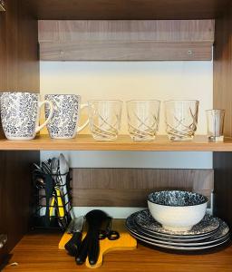 a row of glasses and plates on a shelf at Richloves Haven in Suba