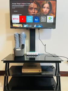 a glass table with a television on top of it at Richloves Haven in Suba