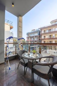 a balcony with a table and chairs on a balcony at The Global Hotel by Platinum I 100m Medanta Hospital I Sector-38 I Gurgaon in Gurgaon