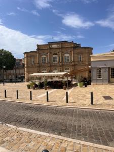 a large building with a brick courtyard in front of it at Charmant duplex in Moulins