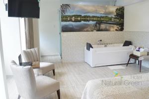 y baño con bañera, mesa y sillas. en Hotel Natural Green Lounge, en Tingo María
