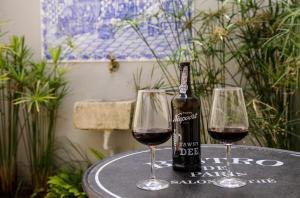 una bottiglia di vino e due bicchieri su un tavolo di Villa Marquês near Tejo River a Cruz Quebrada